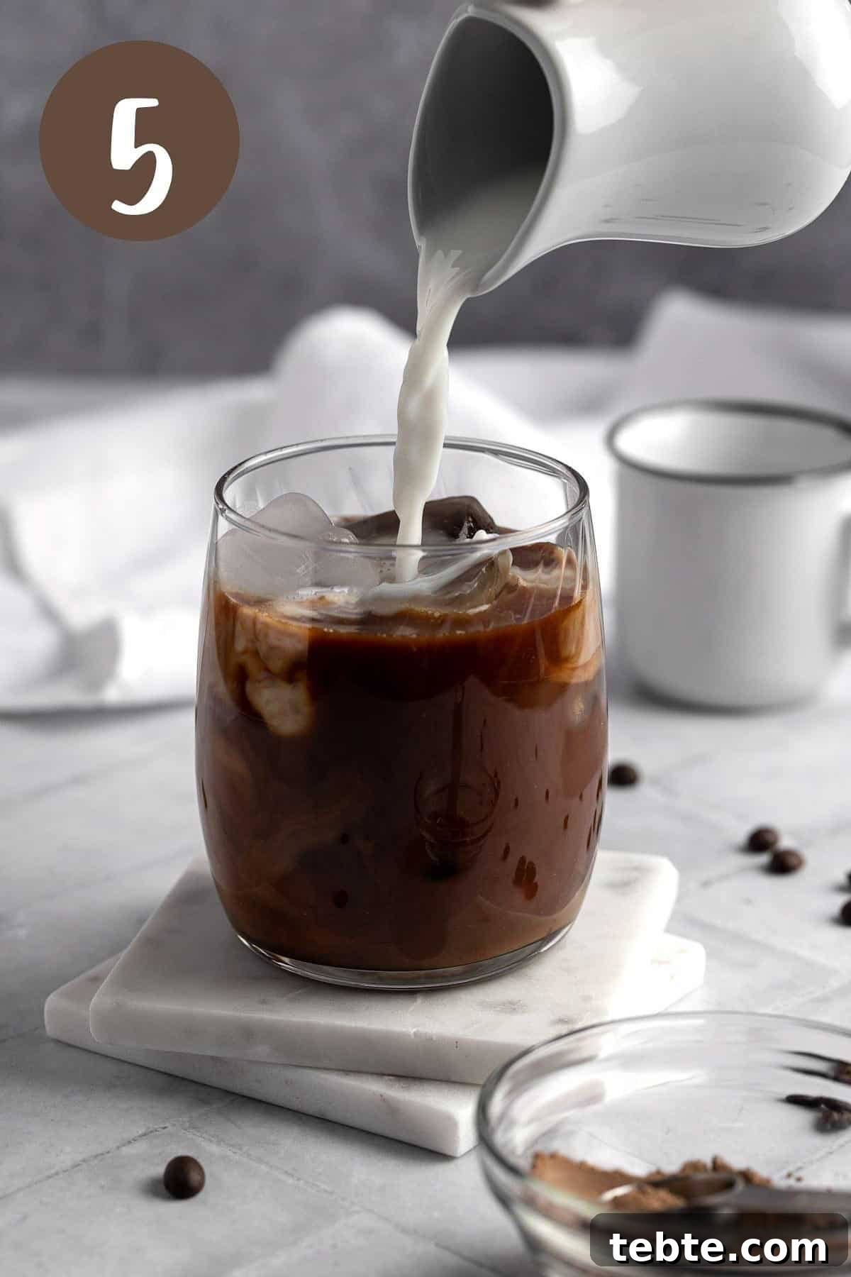 Protein Iced Coffee Recipe: High-Protein Chilled Coffee Drink 6 Process photo illustrating the milk being poured into the iced coffee.