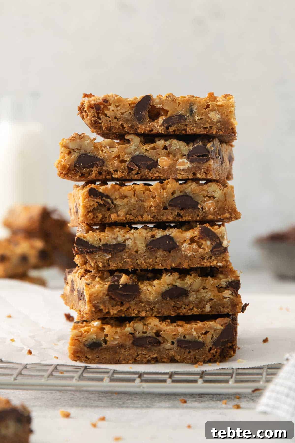 Gluten-Free 7-Layer Cookie Bars: Chewy Chocolate & Coconut Delight 2 7-layer bars stacked on a cooling rack