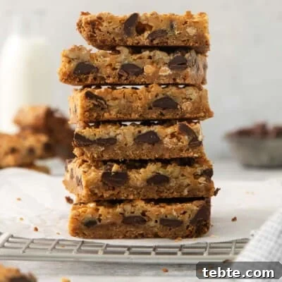 Gluten-Free 7-Layer Cookie Bars: Chewy Chocolate & Coconut Delight 12 7-layer bars stacked on a cooling rack
