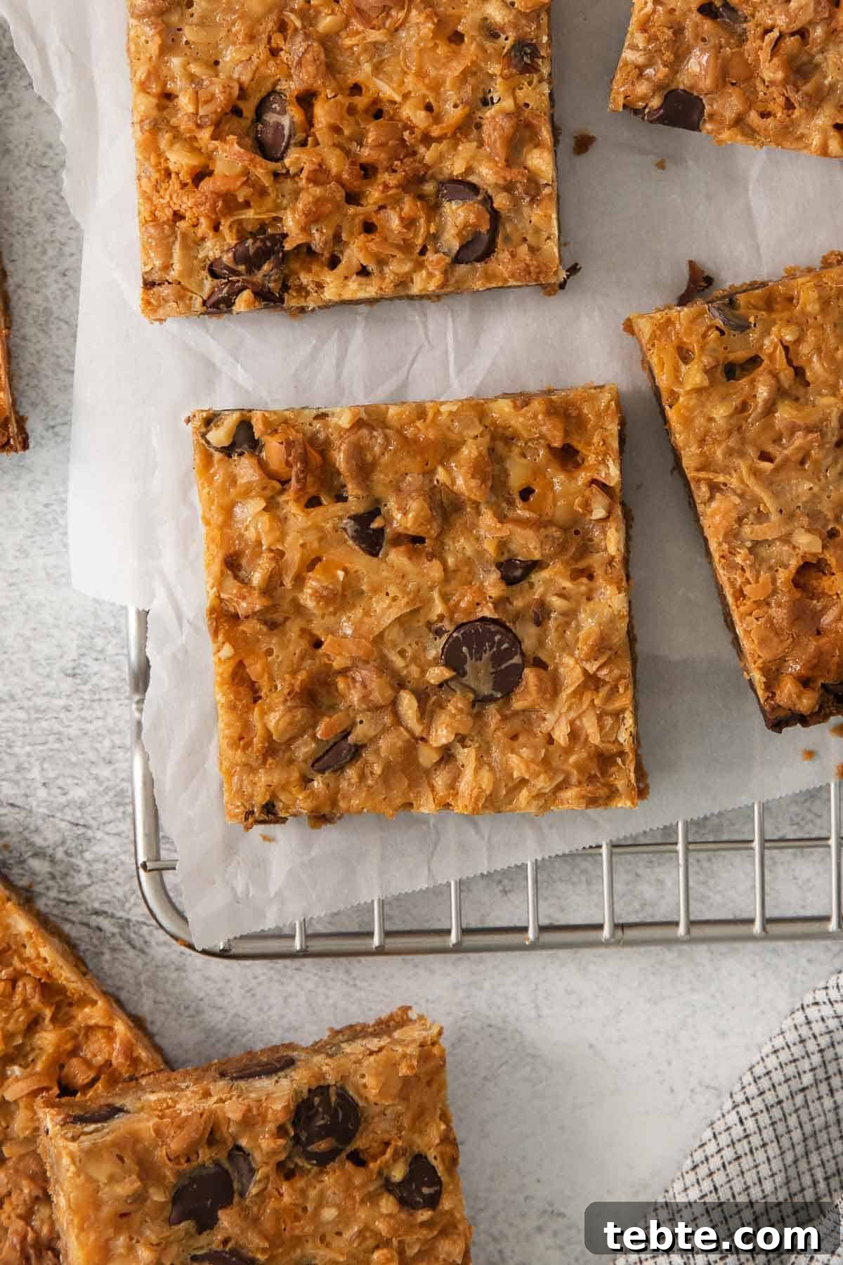 Gluten-Free 7-Layer Cookie Bars: Chewy Chocolate & Coconut Delight 10 7-layer bars cut up on a cooling rack