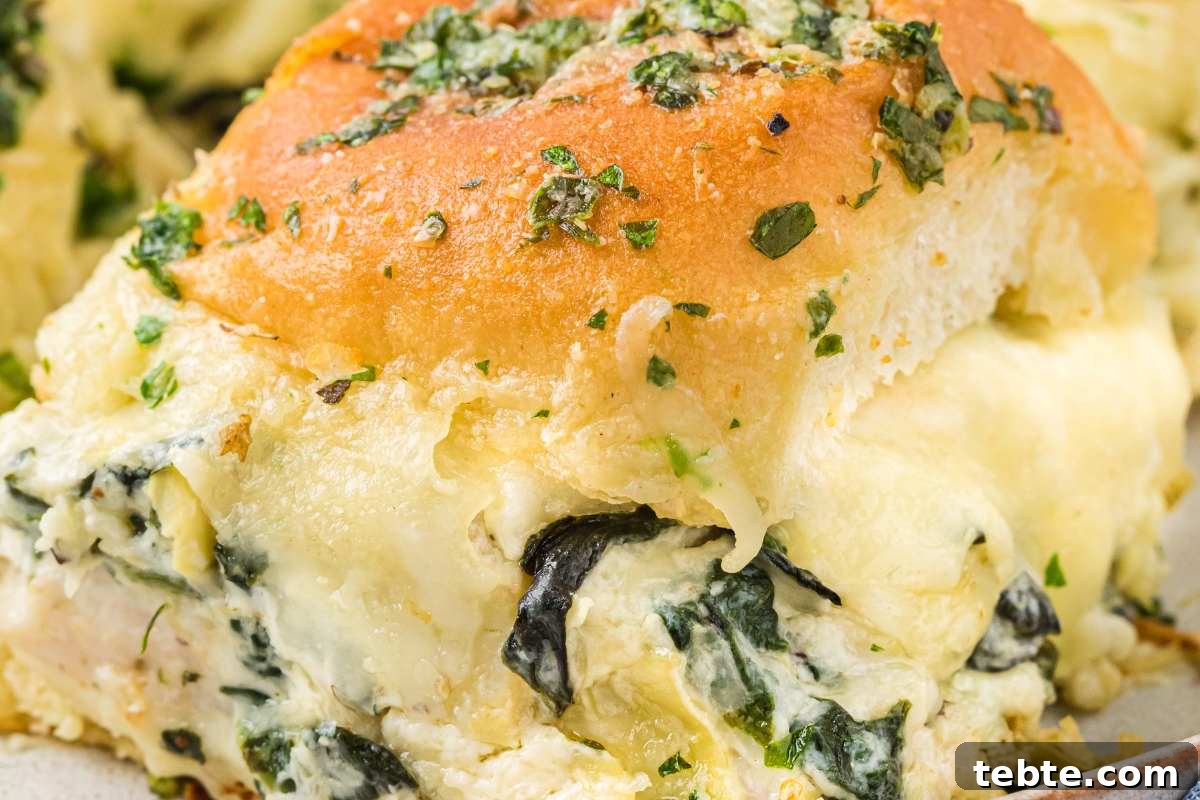 Creamy Chicken and Artichoke Sliders: Savory Party Bites 12 close up of gooey and cheesy slider.