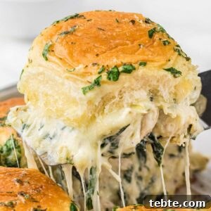 Creamy Chicken and Artichoke Sliders: Savory Party Bites 13 cheesy slider lifted out of pan.