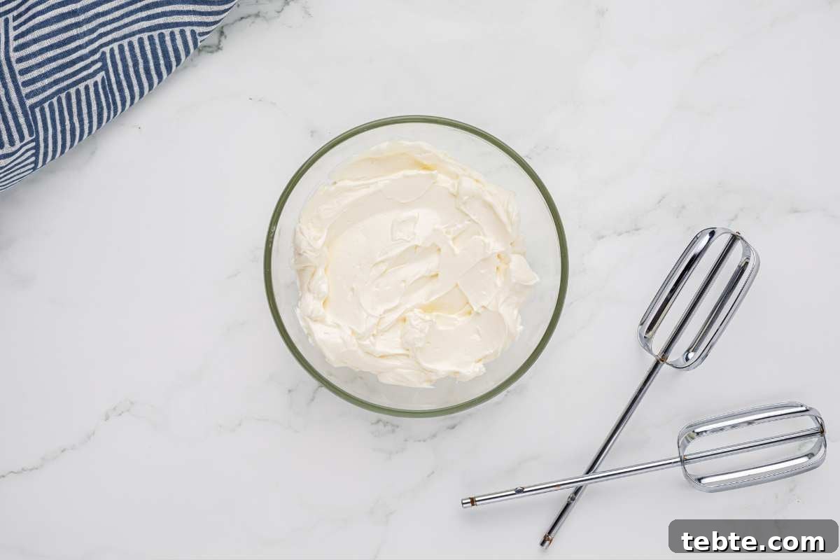 Creamy Chicken and Artichoke Sliders: Savory Party Bites 5 cream cheese filling in glass bowl with beater attachments nearby.