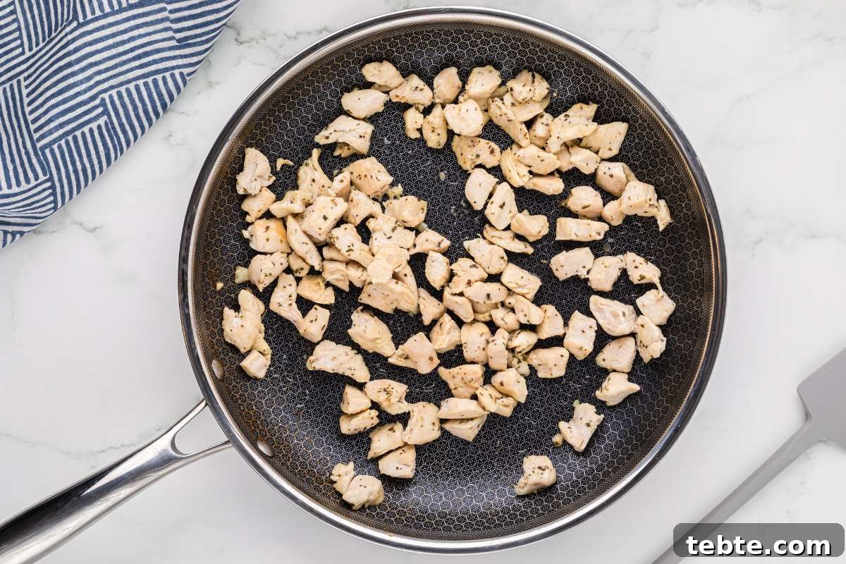 Creamy Chicken and Artichoke Sliders: Savory Party Bites 6 diced cooked chicken in skillet.