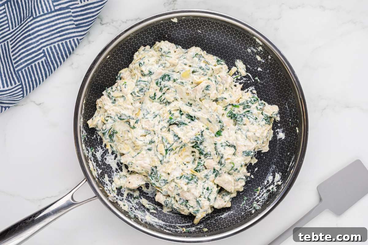 Creamy Chicken and Artichoke Sliders: Savory Party Bites 8 creamy spinach and artichoke mixture in skillet.