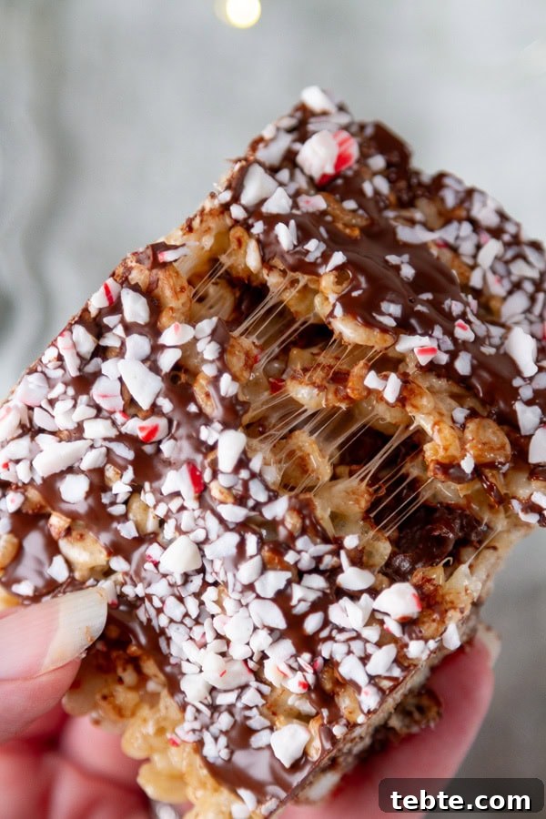 Peppermint Rice Krispies Treats Recipe for Festive Holidays 4 a rice krispies treat broken in half and showing the gooey stretchy marshmallow inside.