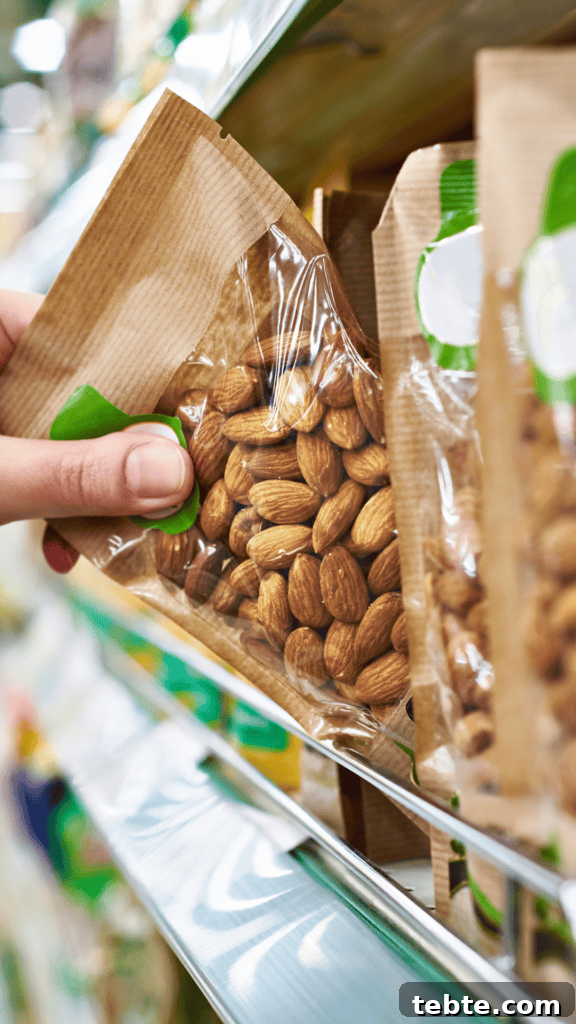 Hand Picking Up a Bag of Almonds at the Grocery Store