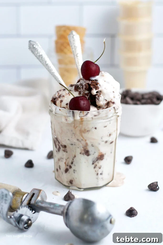 ice cream in a glass jar with cherries on top