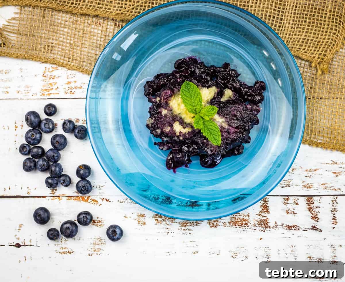 15 Easter Recipes Your Family Will Beg to Eat This Year 12 Blueberry Grunt on a blue plate with ice cream.