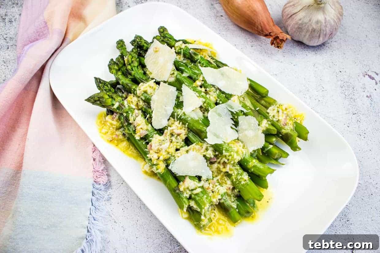 15 Easter Recipes Your Family Will Beg to Eat This Year 15 Asparagus with Lemon and Parmesan on a white platter.