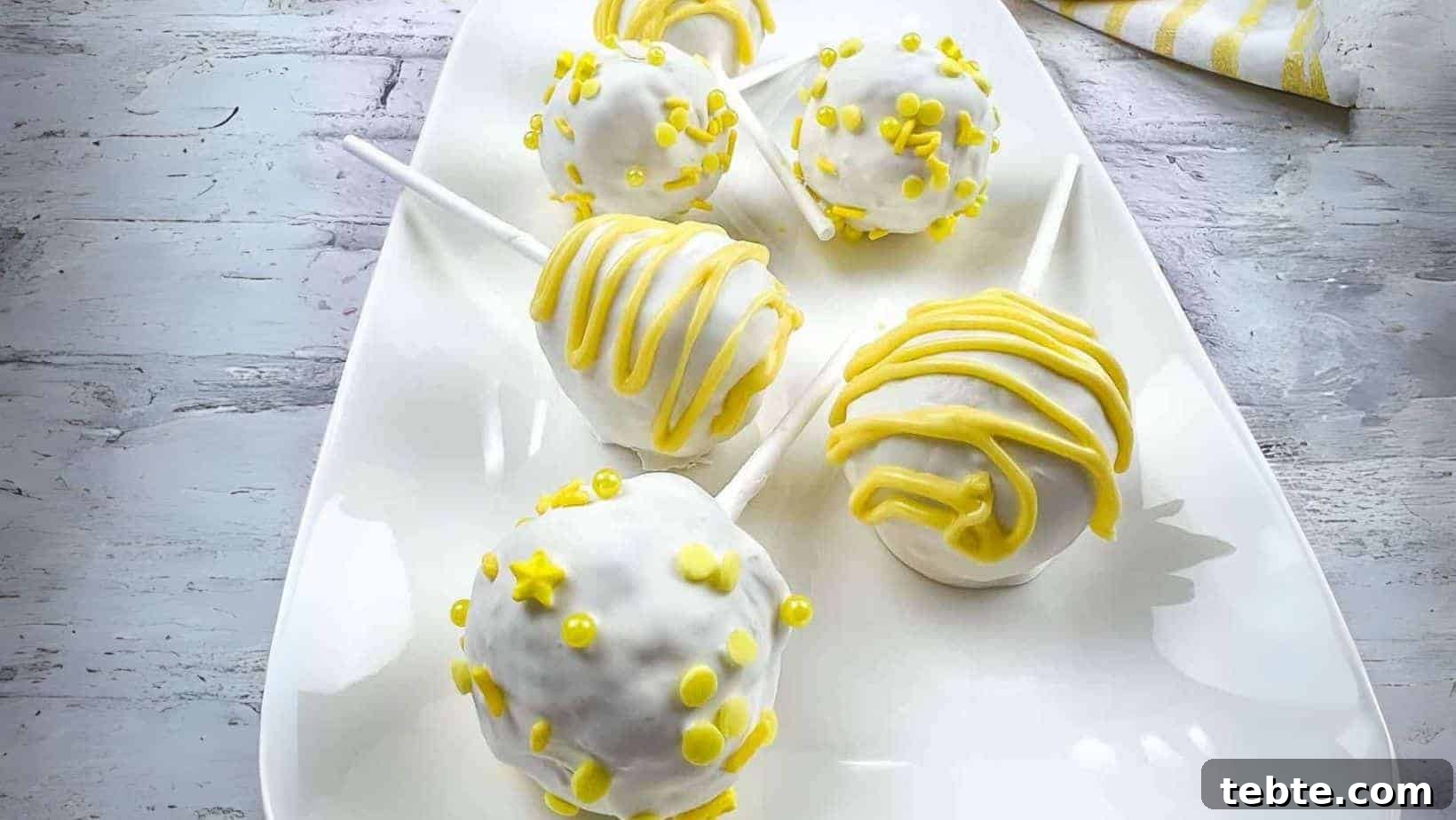 15 Easter Recipes Your Family Will Beg to Eat This Year 9 Lemon cake pops on a white plate.