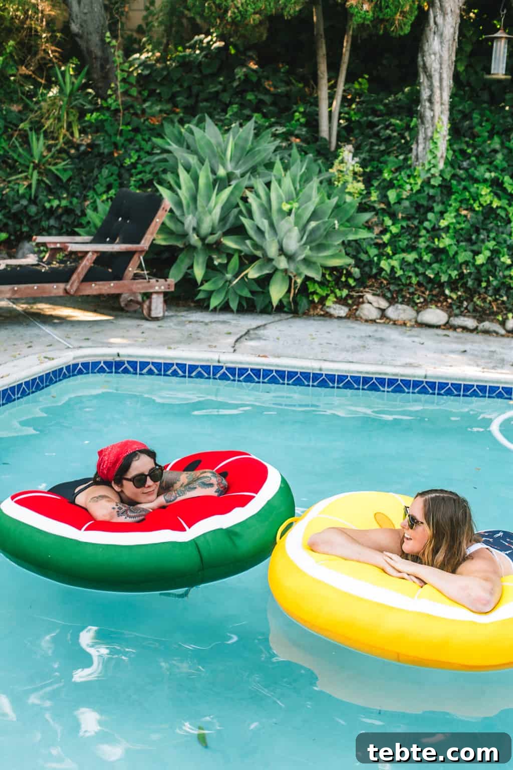 Two girls in a pool on fruit pool floats.