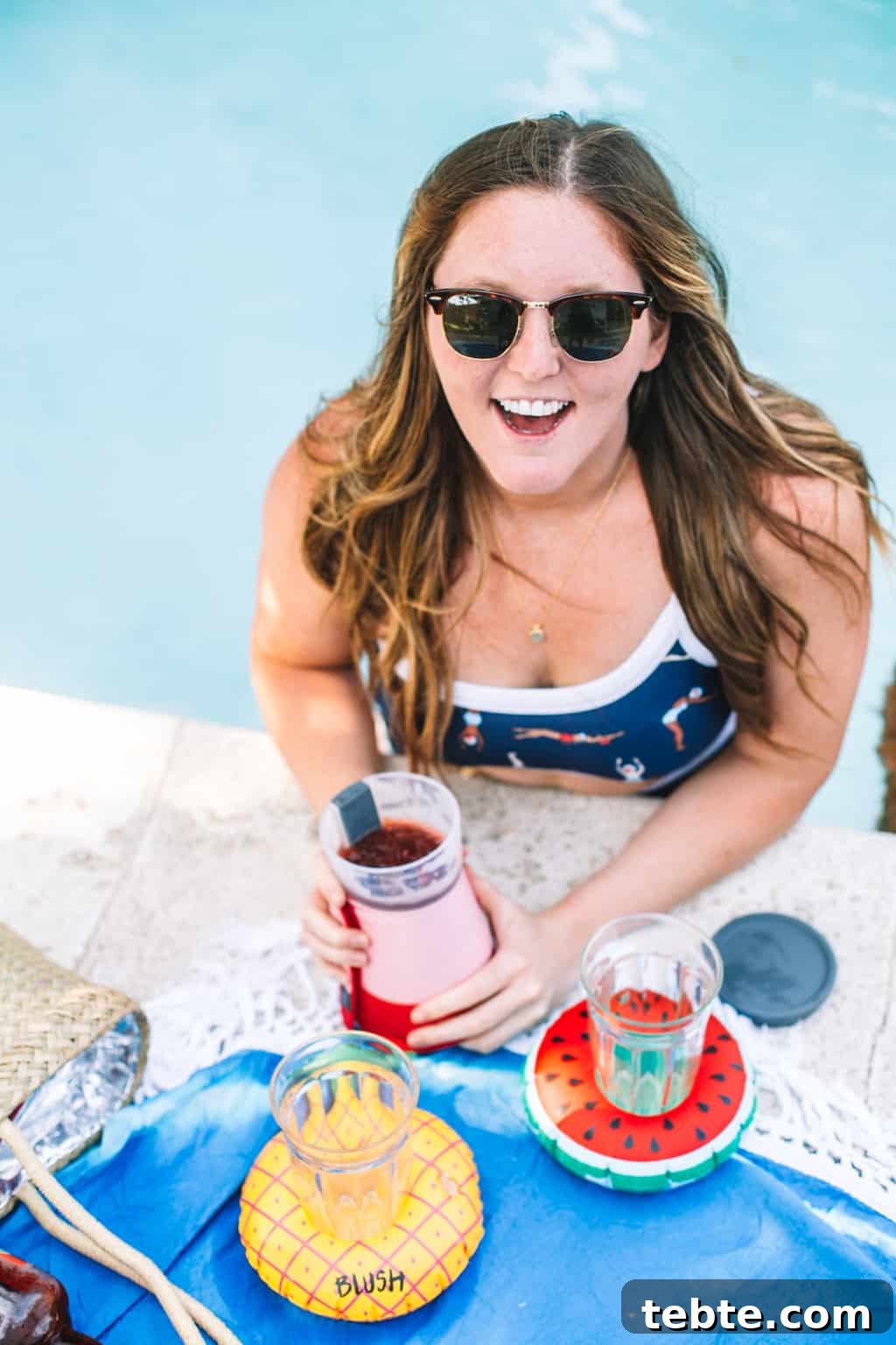 Girl in pool holding onto a frozen cocktail maker.