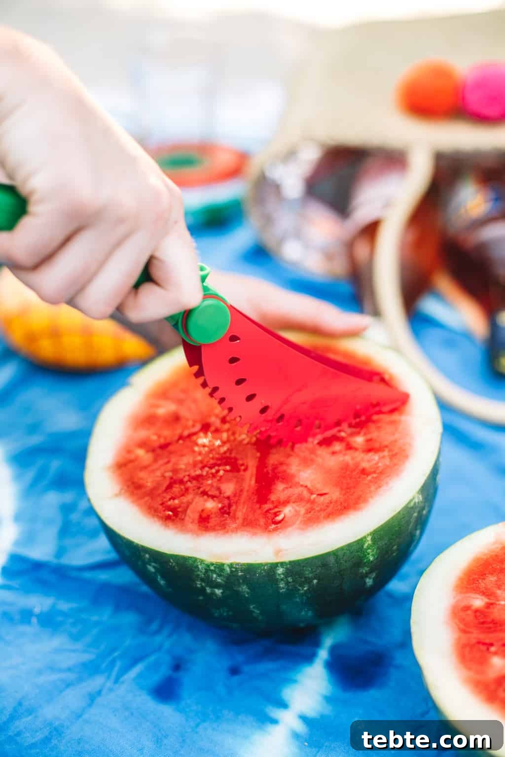 Watermelon slicer cutting into half of a watermelon.