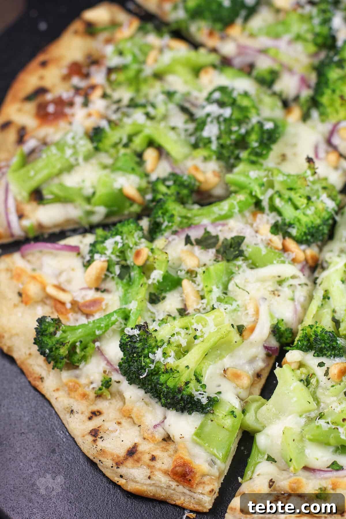 prepared broccoli pizza on black stone