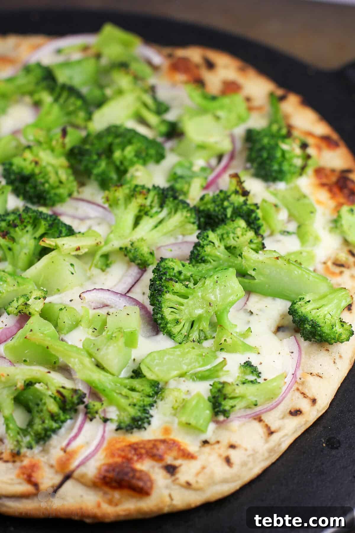 cooked pizza on black stone, right out of the oven before adding last ingredients