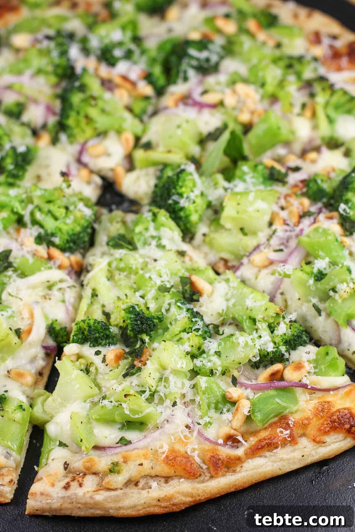 prepared broccoli pizza on black stone