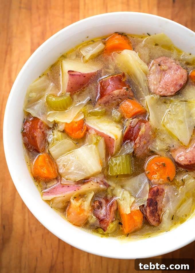 Instant Pot Kielbasa, Cabbage & Potato Soup Recipe 5 Kielbasa Cabbage Potato Soup in a white bowl on a wooden board