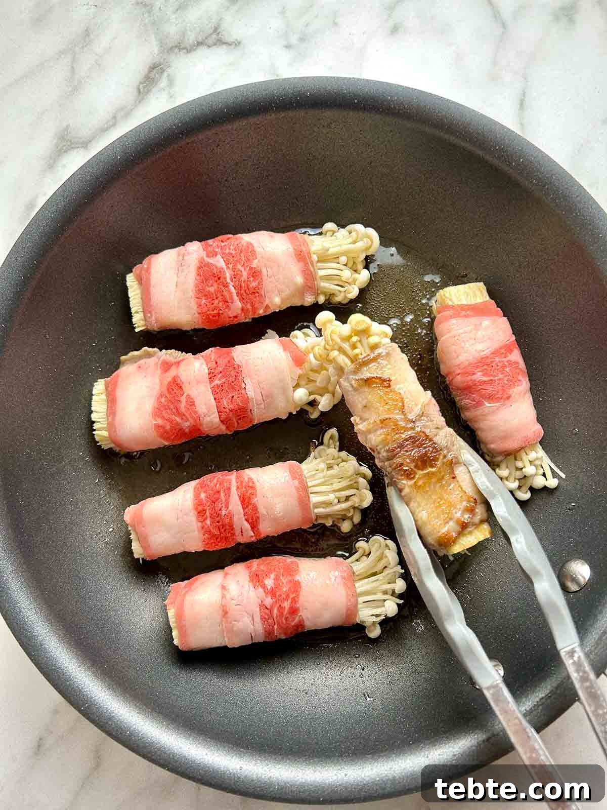 seared enoki beef rolls in pan