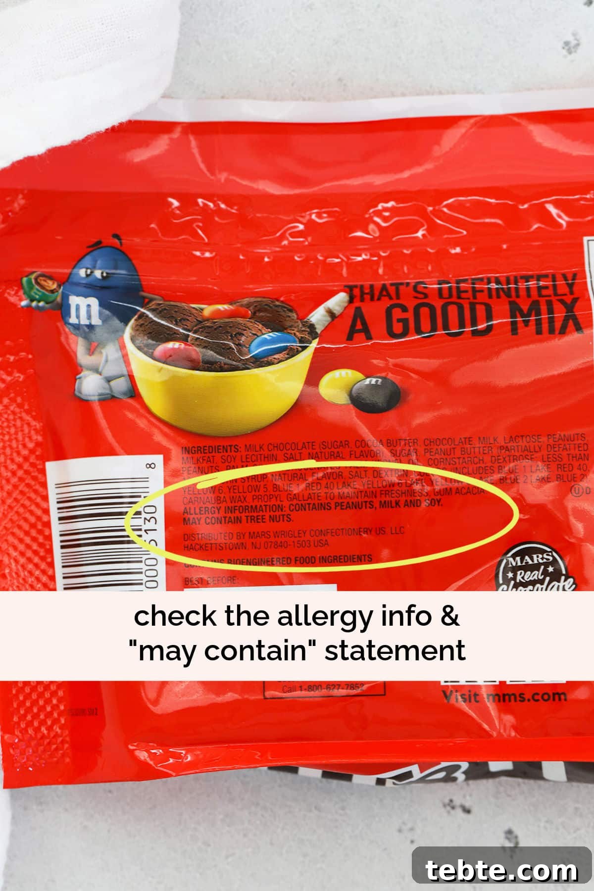 yellow circle highlighting the "may contain" statement on the nutrition facts of a bag of peanut m&ms