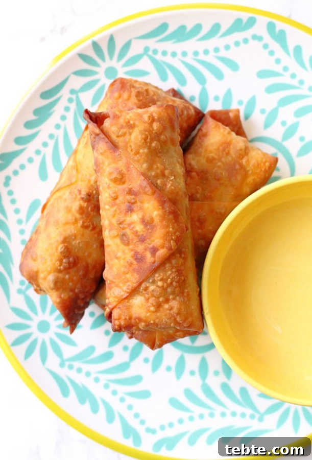 Crispy Scotch Egg Spring Rolls: Savory Snack Recipe 2 scotch egg rolls plated with a small bowl of mustard dipping sauce