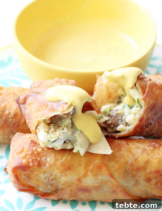 Crispy Scotch Egg Spring Rolls: Savory Snack Recipe 3 scotch egg rolls plated and cut in half to show egg and sausage filling