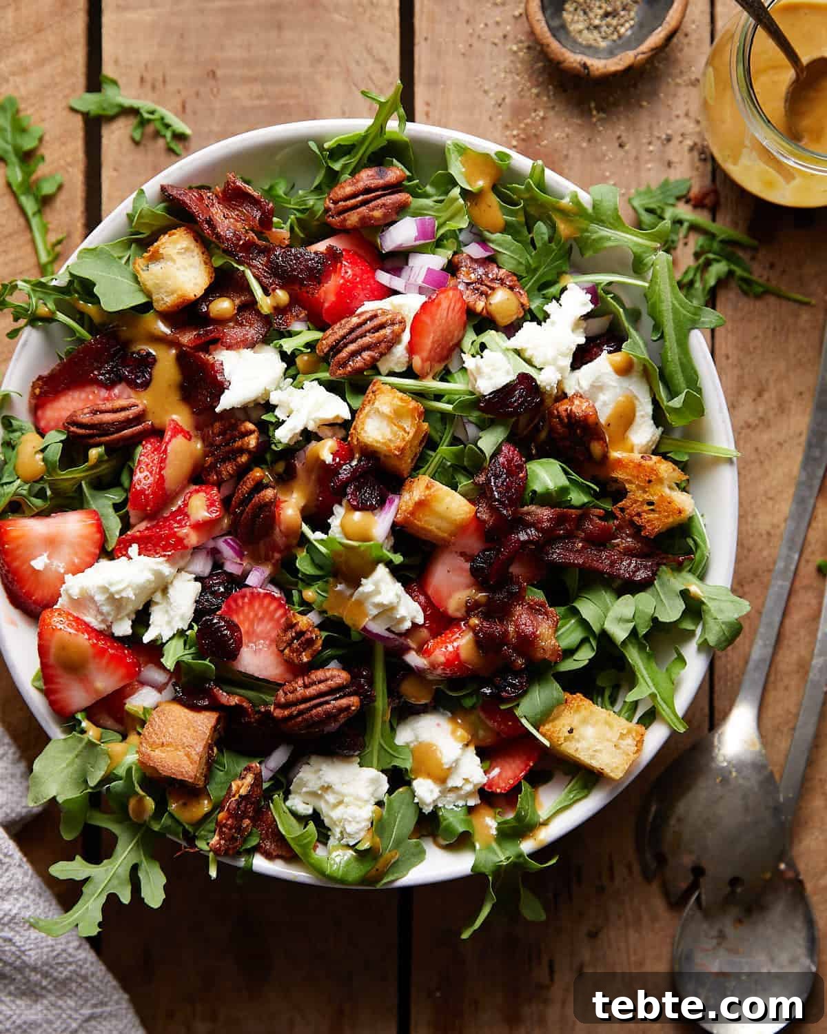 41 Fresh Fall Salad Recipes to Try This Season 15 A full salad in a bowl alongside metal serving utensils. The salad is filled with greens, bacon, pecans, croutons, strawberries and goat cheese.