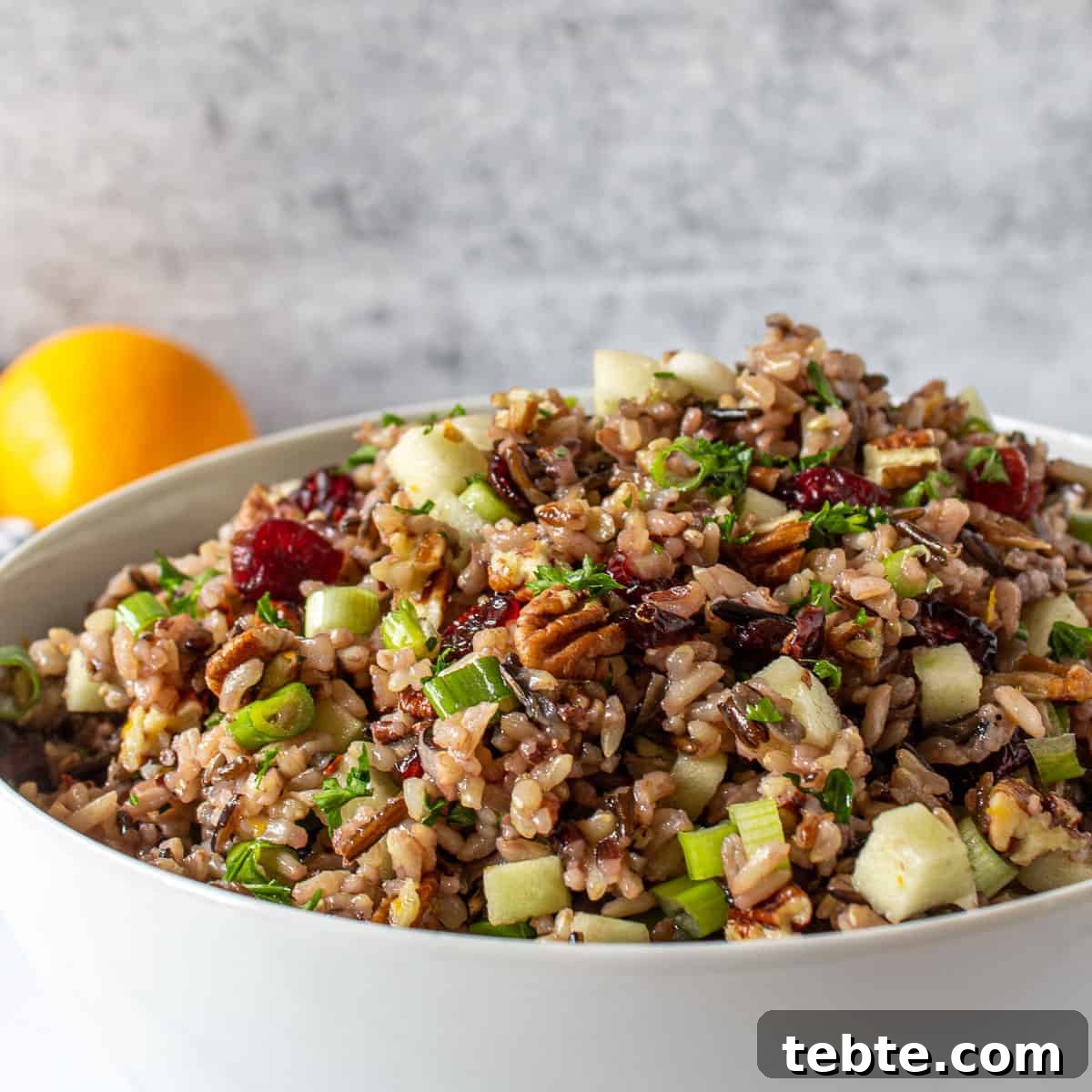 41 Fresh Fall Salad Recipes to Try This Season 25 A white bowl piled high with wild rice, pecans, green apples, cranberries and sprinkled with green herbs. A lemon is showing off in the distance.
