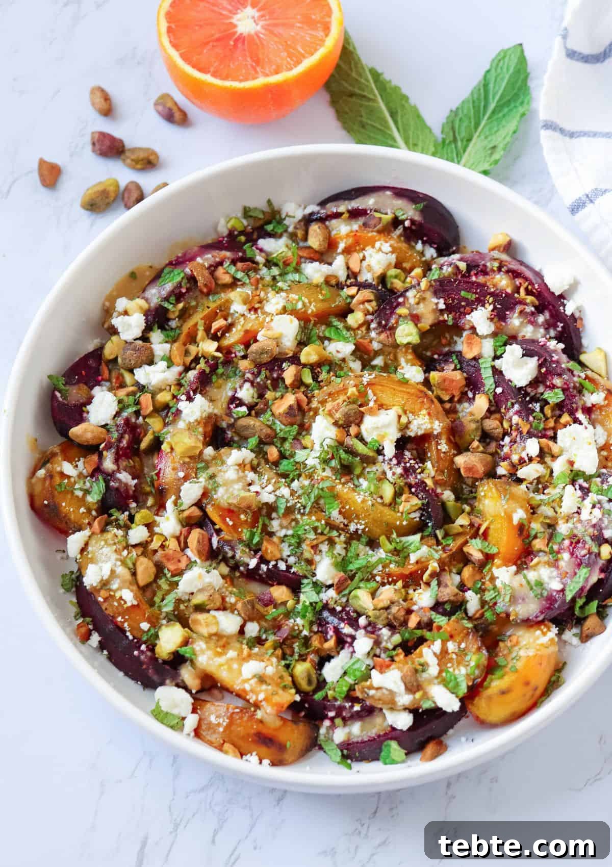41 Fresh Fall Salad Recipes to Try This Season 5 Sliced roasted beets and oranges topped with chopped pistachios, mint and crumbles of feta in a white bowl.