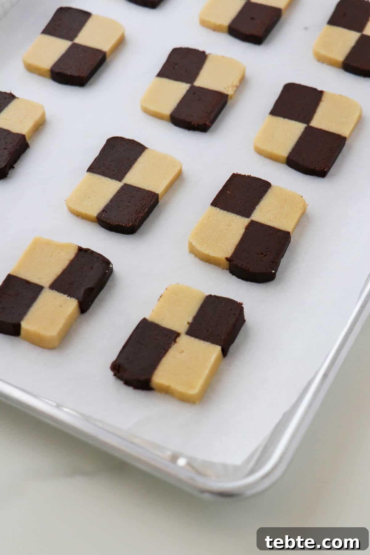 Unbaked checkerboard cookies on a baking sheet.