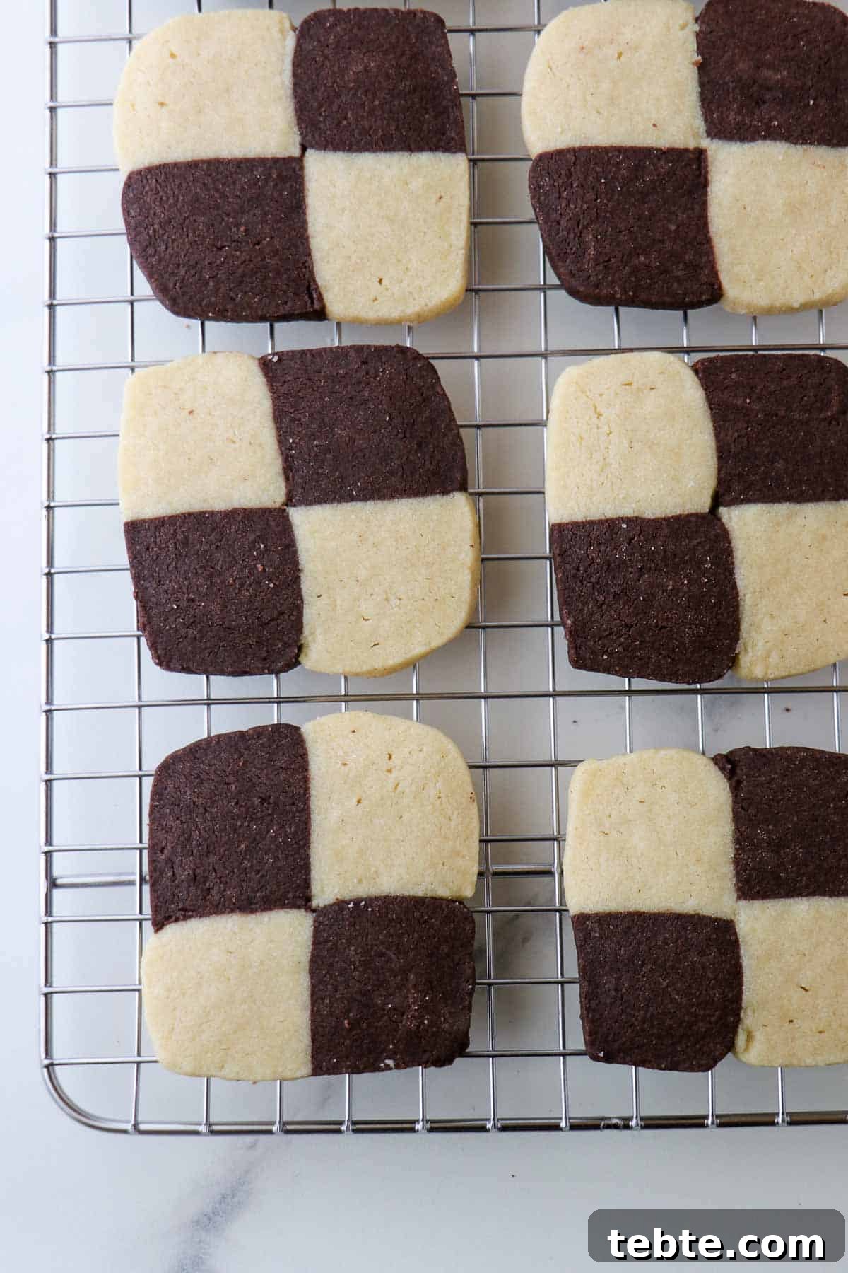 Checkerboard cookies on a metal cooling rack.