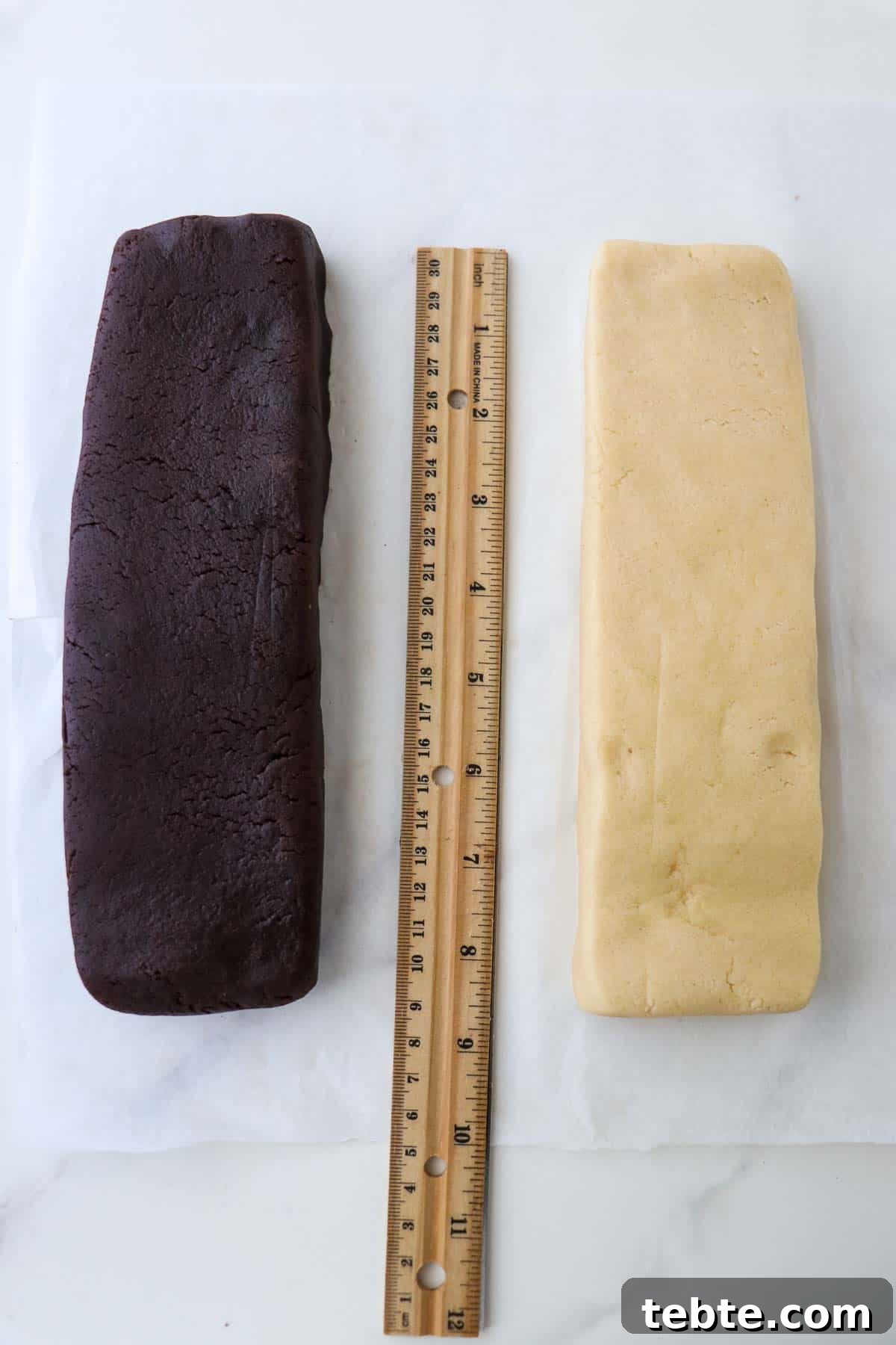 Two rectangles of cookie dough, one chocolate and one vanilla with a ruler in between them.