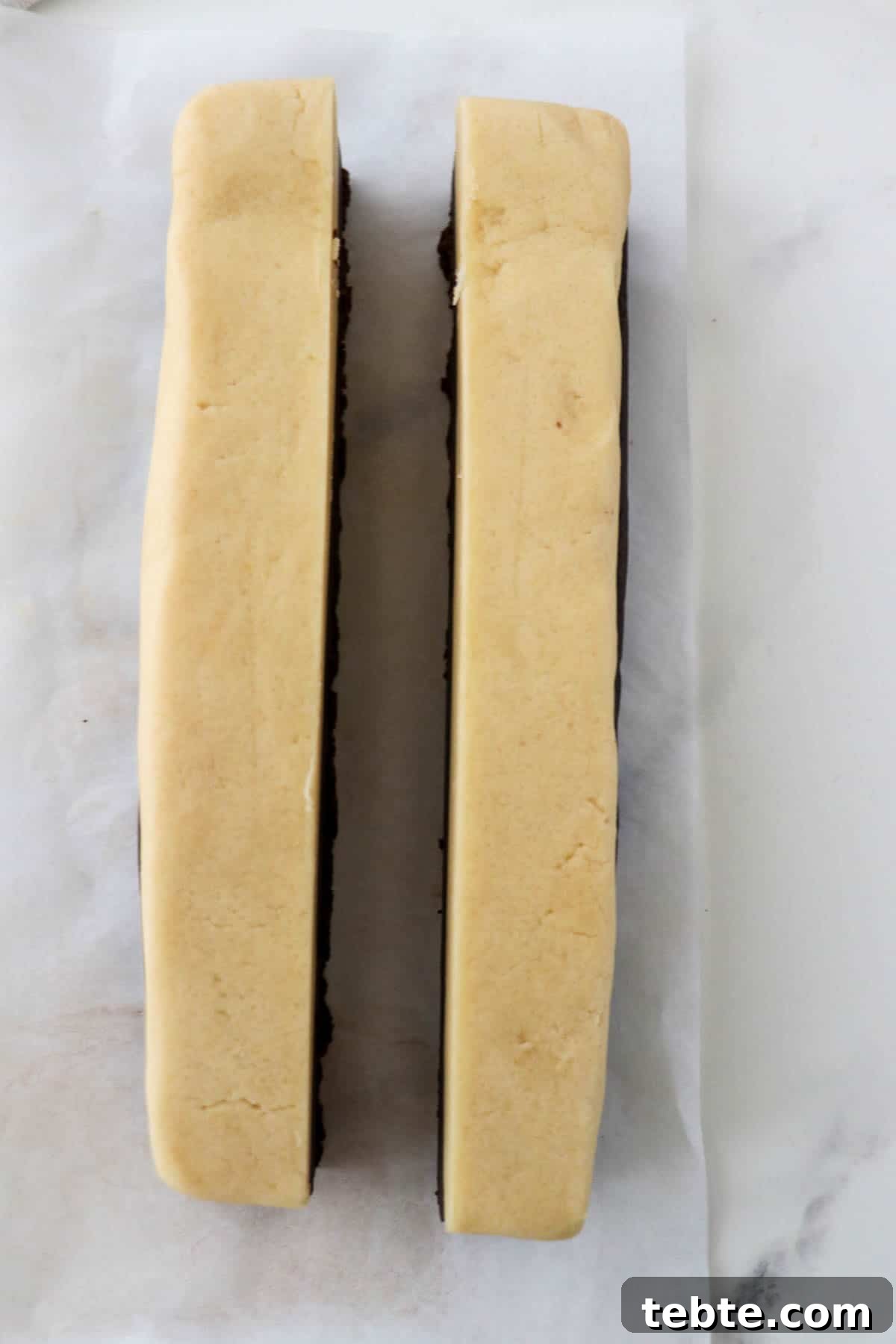 Rectangle of cookie dough cut in half lengthwise.