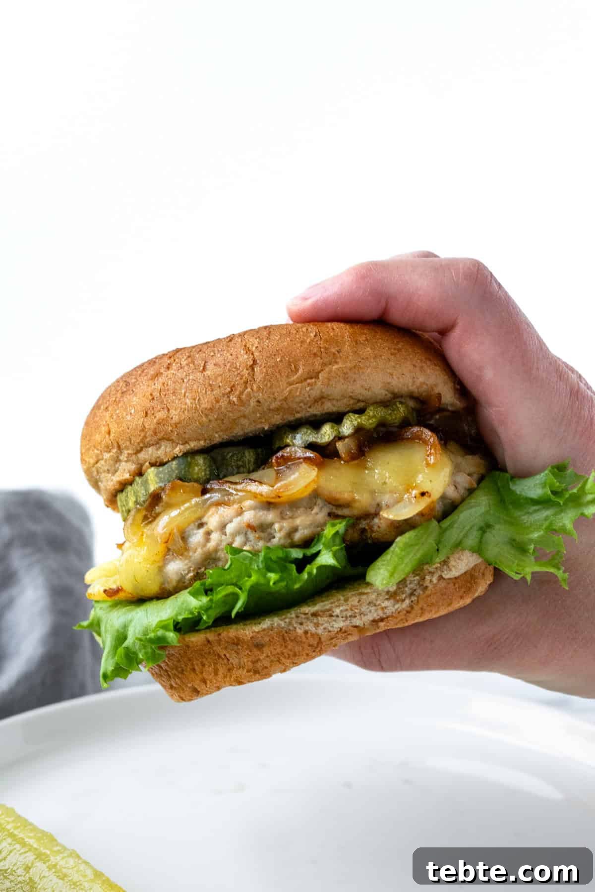 Juicy Turkey Smash Burgers with Crispy Edges and Melty Cheese 9 Hand Holding a Turkey Smash Burger.