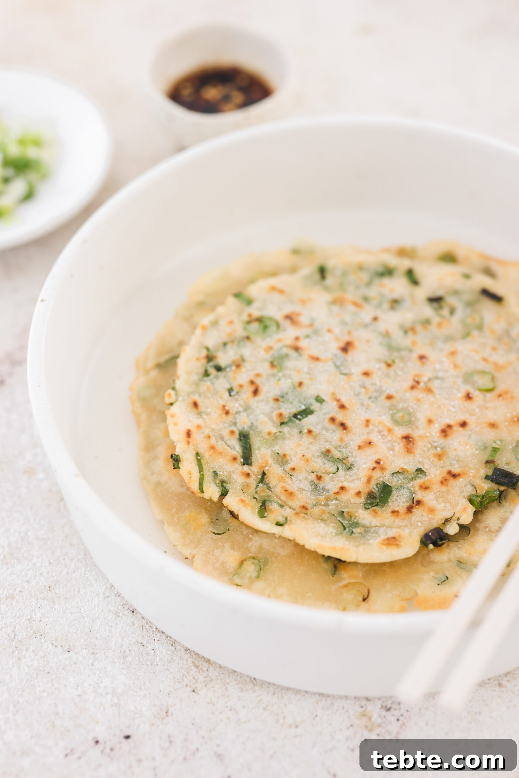 an up close photo of cooked taiwanese pancakes in a white dish