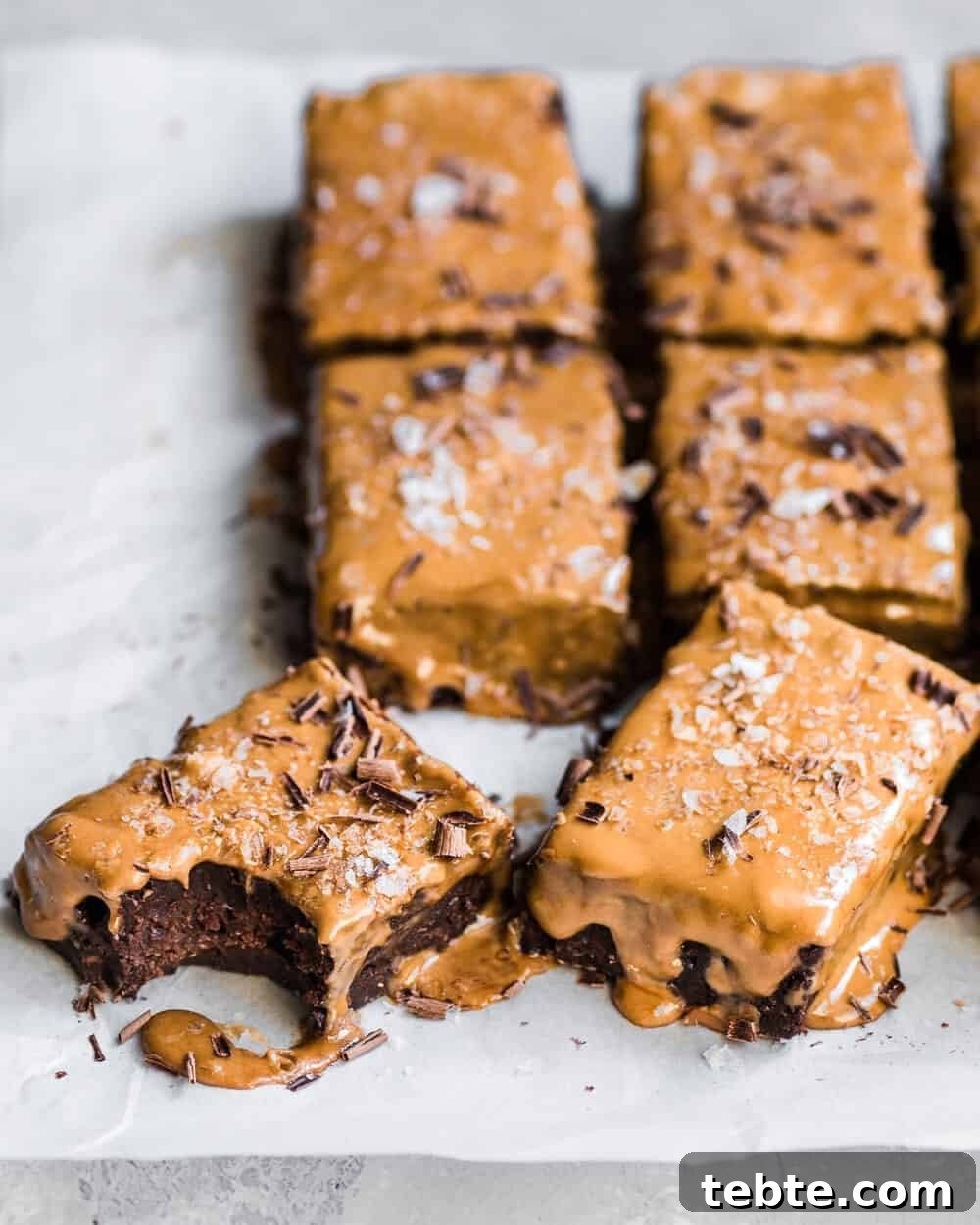 Vegan Gingerbread Brownies with Espresso Glaze Recipe 2 Six gingerbread brownies on parchment paper.