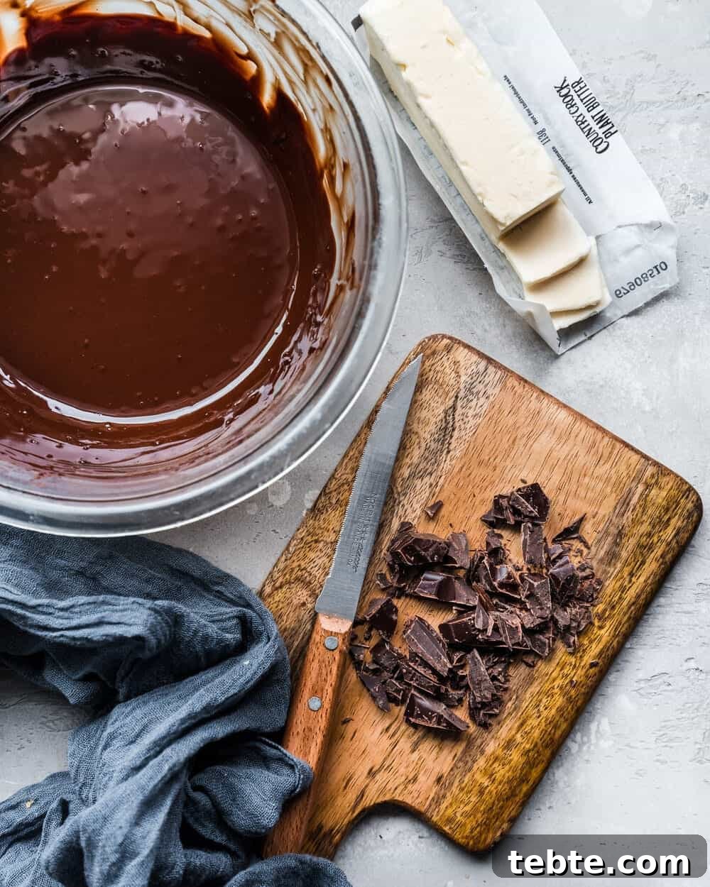 Vegan Gingerbread Brownies with Espresso Glaze Recipe 5 Chopped chocolate on a cutting board, a bowl of melted chocolate and vegan butter.