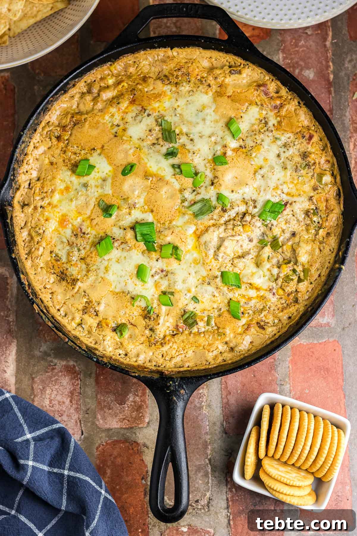 Savory Baked Cowboy Dip Recipe for Parties and Game Day 2 Baked cowboy dip in a skillet next to some crackers.