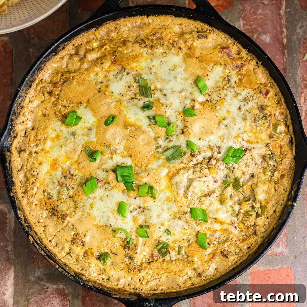 Savory Baked Cowboy Dip Recipe for Parties and Game Day 4 Overhead view of baked cowboy dip in an iron skillet.