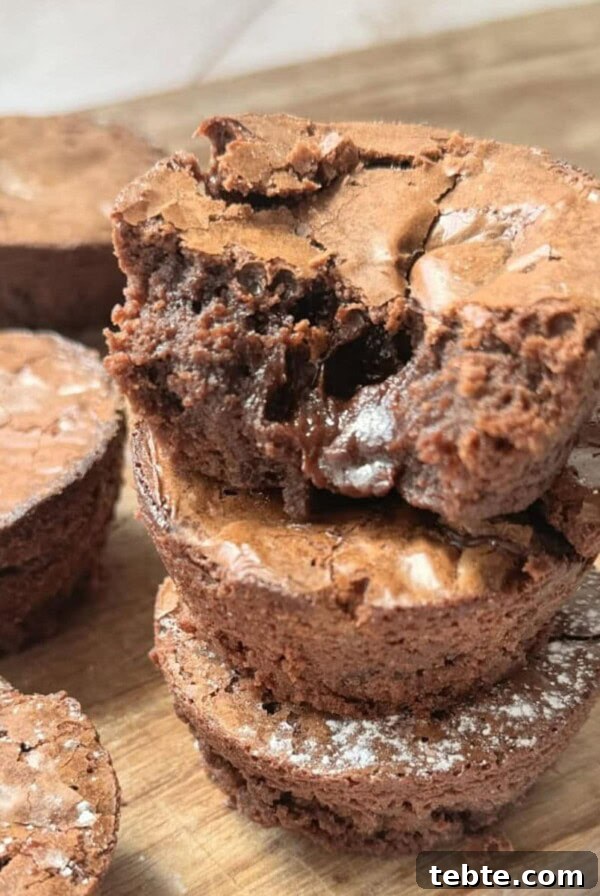 Double Chocolate Marble Brownies: Dark & White Swirl Recipe 12 a stack of brownie bites on a wooden chopping board.