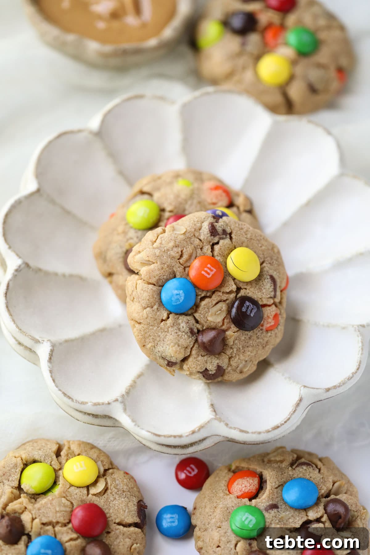 Soft Chewy Monster Cookies with Chocolate, Oats & Peanut Butter 7 monster cookies on a white plate.