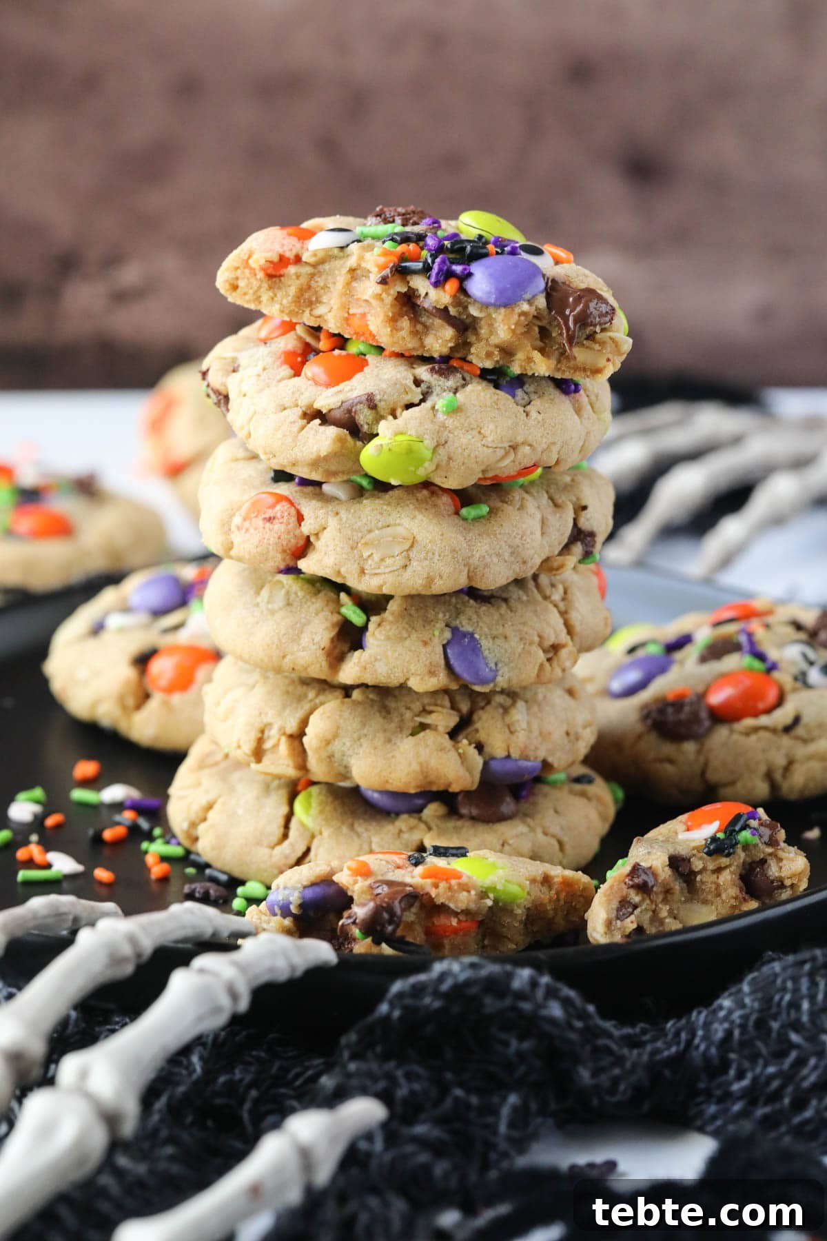 Soft Chewy Monster Cookies with Chocolate, Oats & Peanut Butter 10 monster cookies stacked on a black plate.