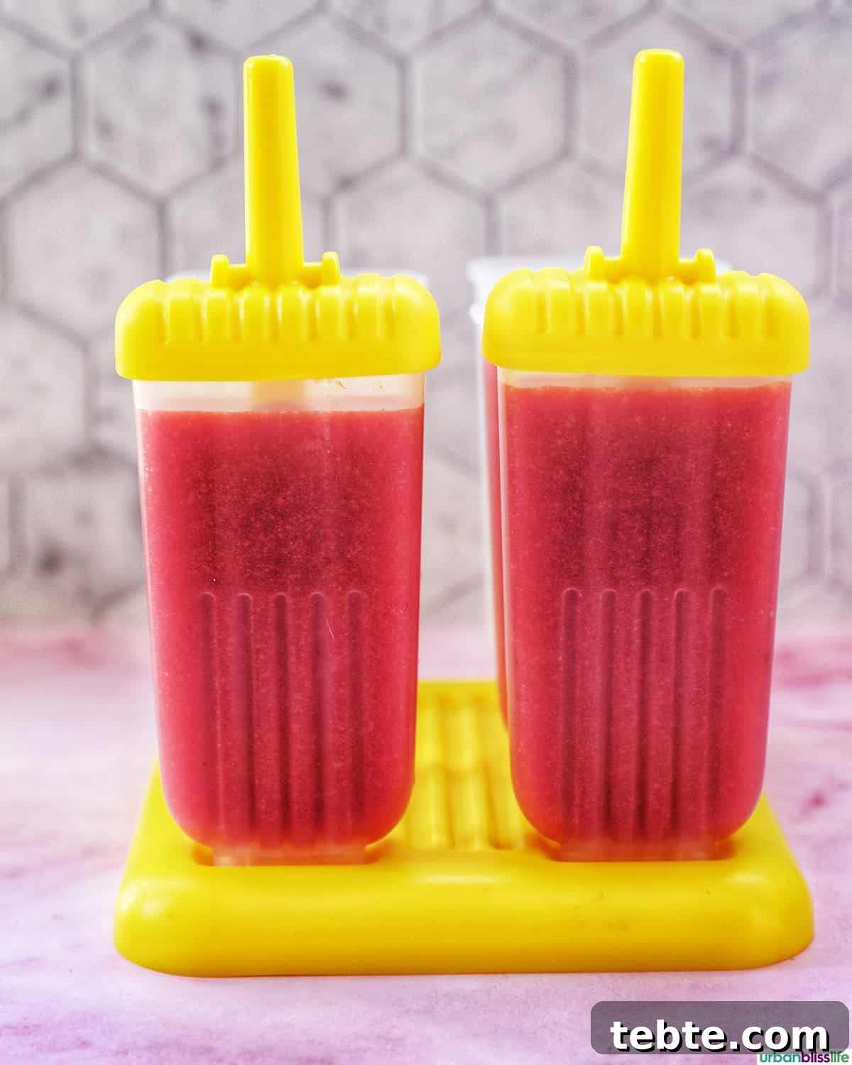 Homemade Strawberry Popsicles Recipe 8 two strawberry fruit popsicles in popsicle molds.