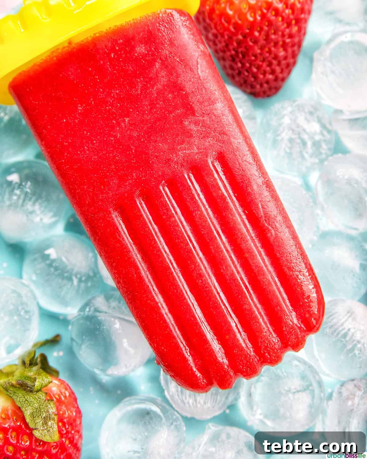 Homemade Strawberry Popsicles Recipe 10 strawberry fruit popsicle on ice.