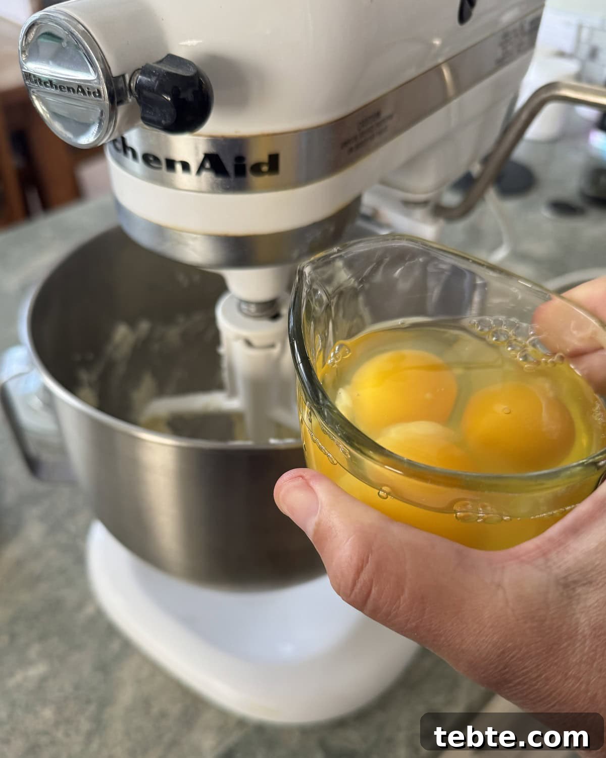 Sheet-Pan Scone Cake Recipe 6 Adding eggs to a mixing bowl of a stand mixer.