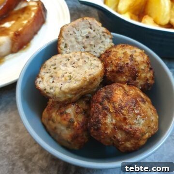 Sausage Stuffing with Sage and Onion 14 Sage and onion sausage stuffing balls in a dish with one cut in half to show the texture.