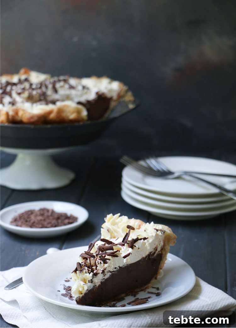 Classic Chocolate Cream Pie Made from Scratch 2 Slice of chocolate cream pie on a white plate with the whole pie in the background