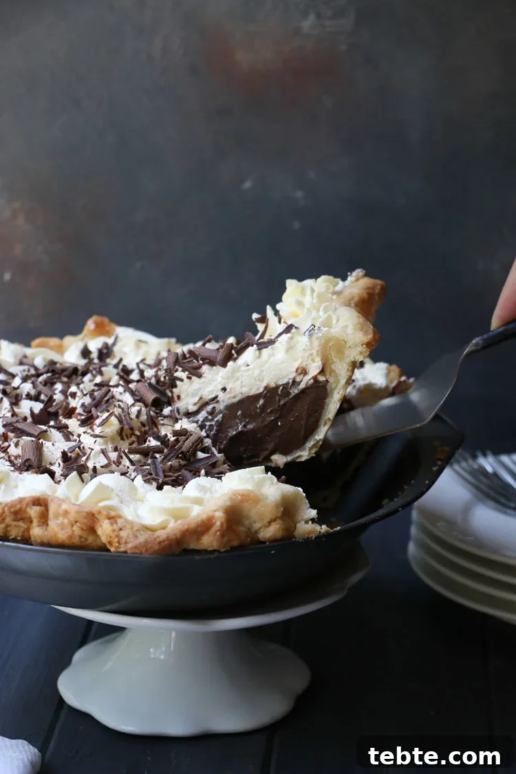 Classic Chocolate Cream Pie Made from Scratch 9 side view of removing one slice of chocolate cream pie from the pie pan
