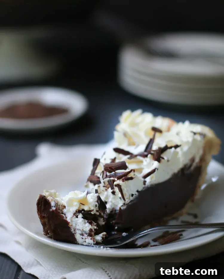 Classic Chocolate Cream Pie Made from Scratch 10 slice of chocolate cream pie with a forkful resting on the plate