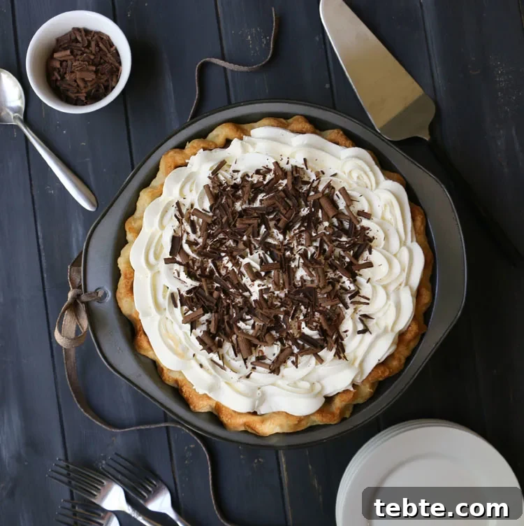 Classic Chocolate Cream Pie Made from Scratch 4 Overhead photo of whole chocolate cream pie with plates, forks, pie server and bowl of chocolate shavings
